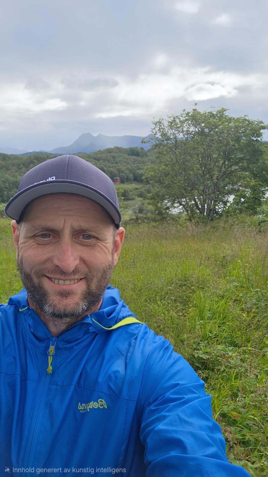 Frank i ullgenser smiler i kystlandskap